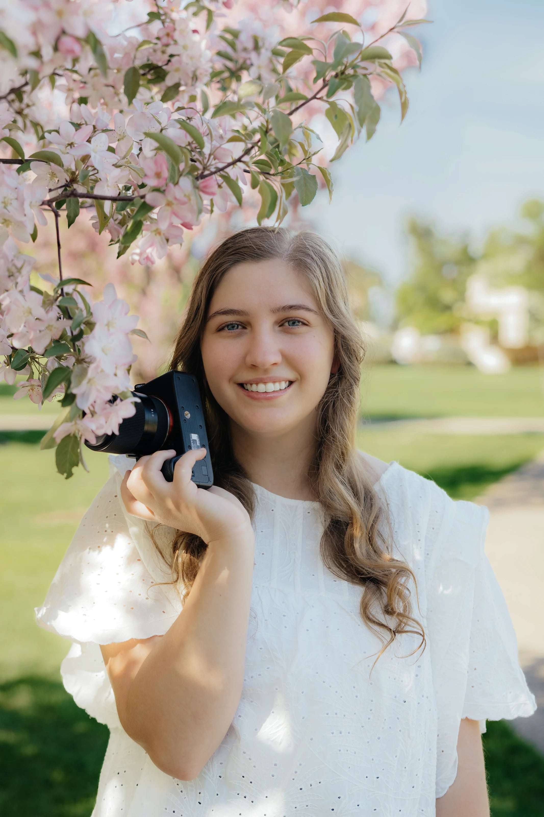 Lauren Sukkau holding her camera outdoors